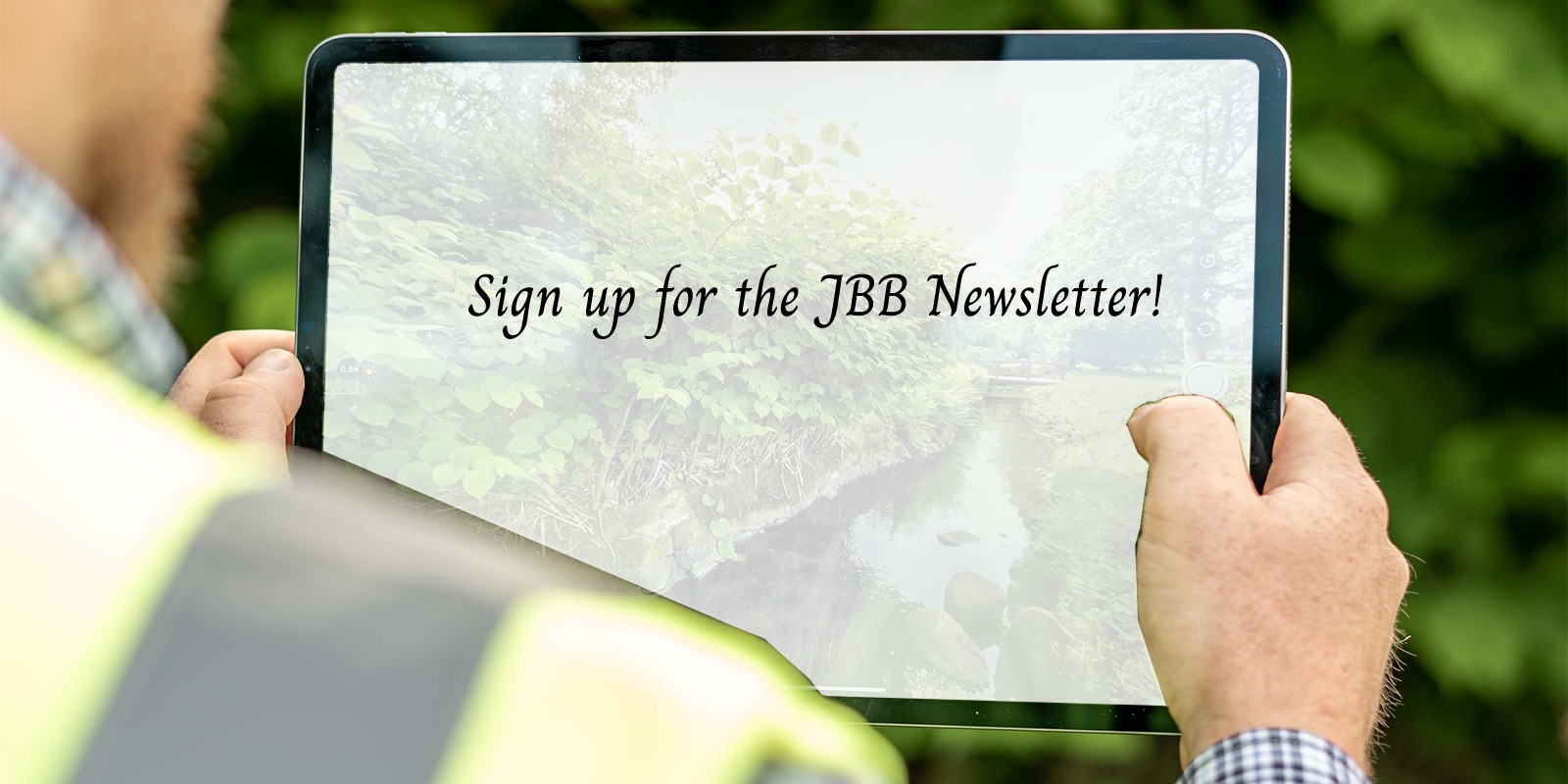 Man holding an iPad that displays the text "Sign up for the JBB Newsletter!"