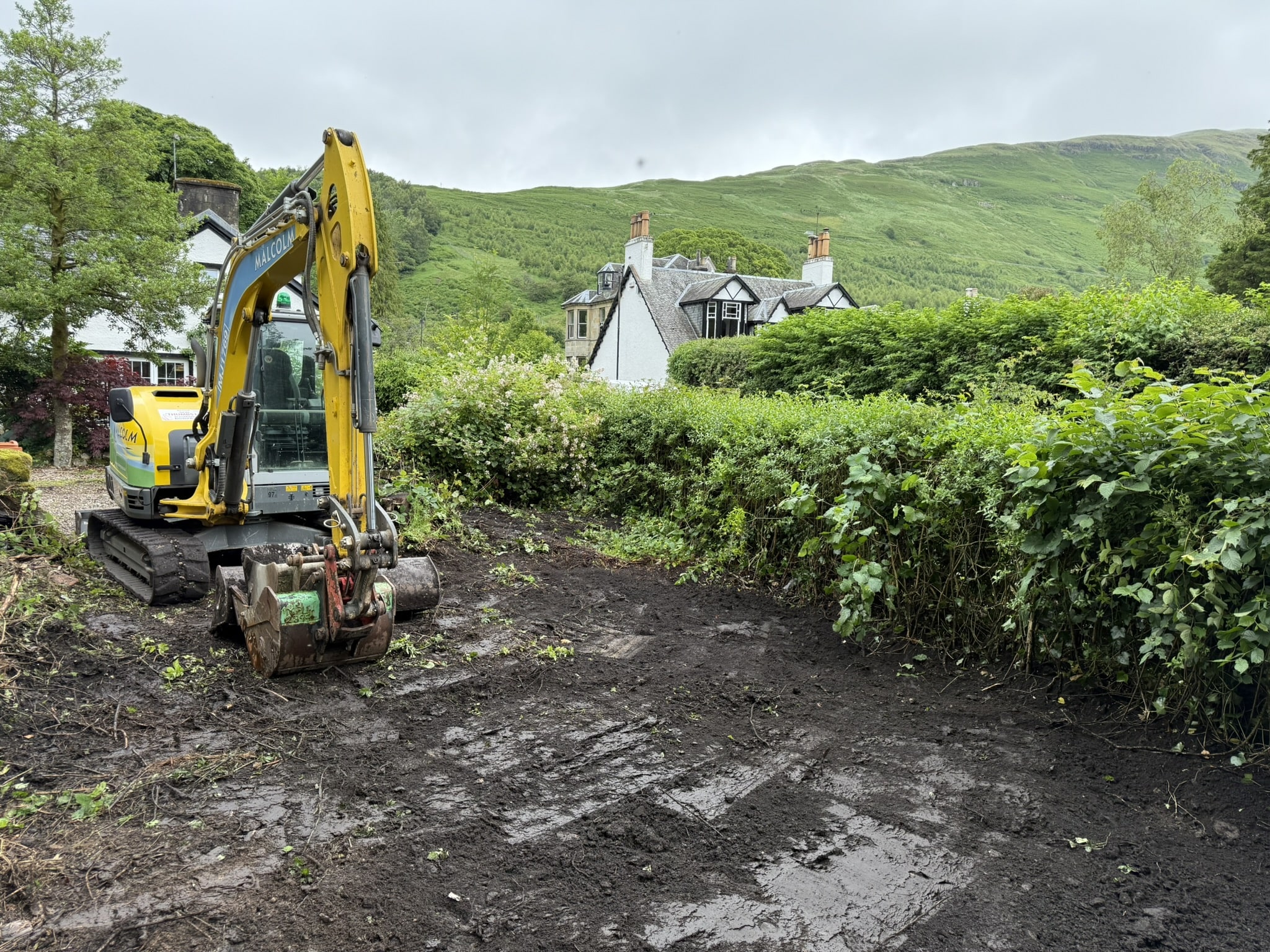 Excavator lifting contaminated soil as part of Japanese Knotweed excavation at a rural East Dunbartonshire site.